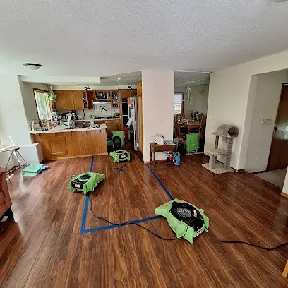 Air movers drying a laminate floor after a water leak in a Beaverton home